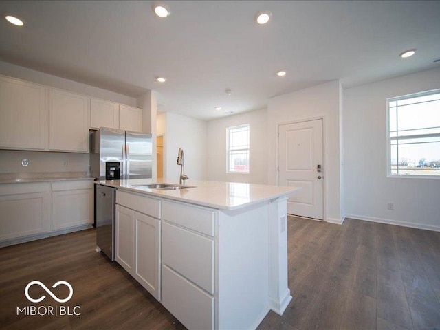 kitchen with stainless steel appliances, dark wood finished floors, a sink, and recessed lighting