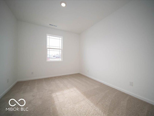 spare room featuring carpet flooring, visible vents, and baseboards