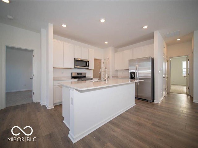 kitchen with white cabinets, dark wood-style floors, stainless steel appliances, light countertops, and a sink