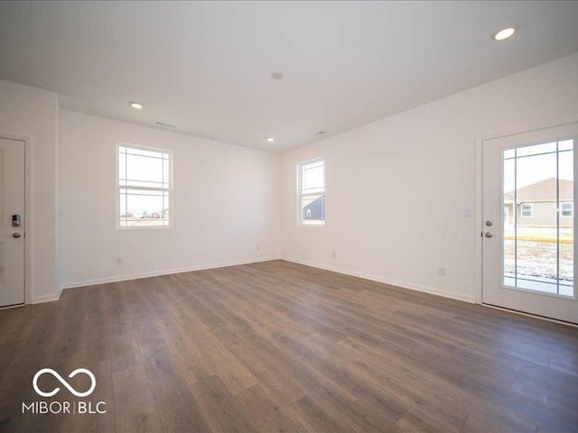 spare room with baseboards, dark wood finished floors, and recessed lighting