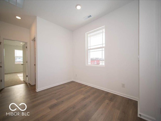 unfurnished room featuring plenty of natural light, visible vents, dark wood finished floors, and recessed lighting