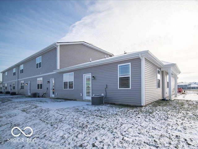 snow covered back of property with central AC unit