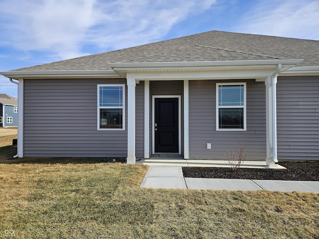 exterior space featuring a yard and roof with shingles