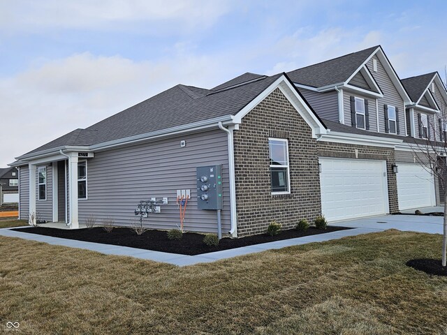 view of side of home with a garage and a yard