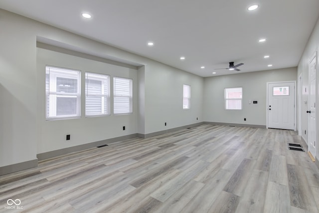 unfurnished living room with ceiling fan and light hardwood / wood-style flooring