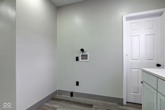 laundry area featuring cabinets, washer hookup, and light hardwood / wood-style flooring