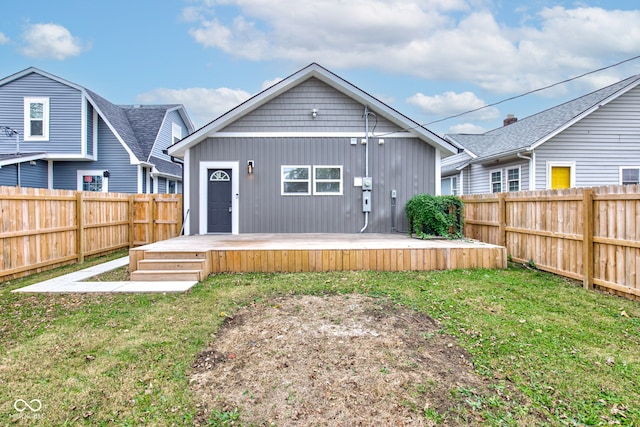 rear view of property featuring a wooden deck and a yard