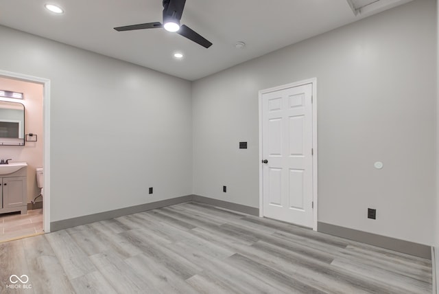 empty room with ceiling fan, sink, and light hardwood / wood-style flooring