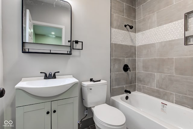 full bathroom featuring tiled shower / bath, vanity, and toilet