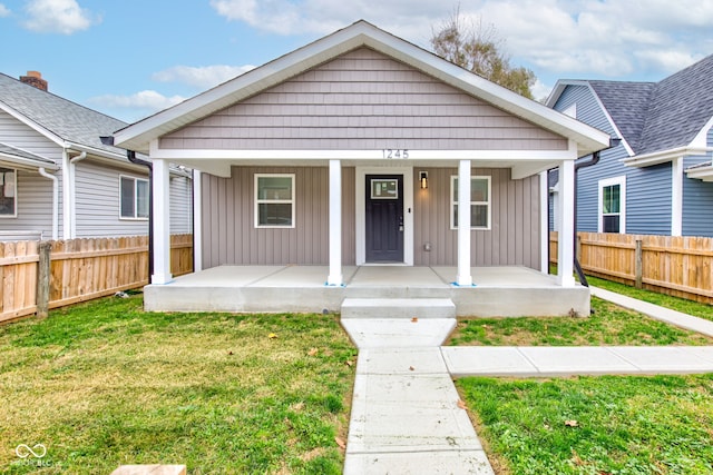 bungalow-style house featuring covered porch and a front yard