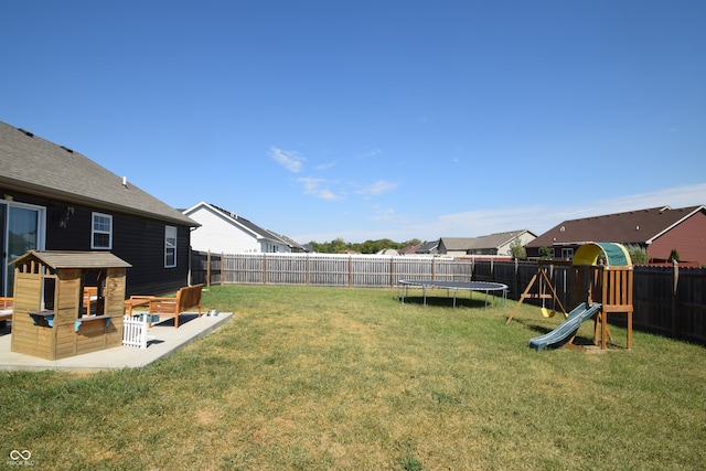 view of yard featuring a trampoline, a playground, and a patio