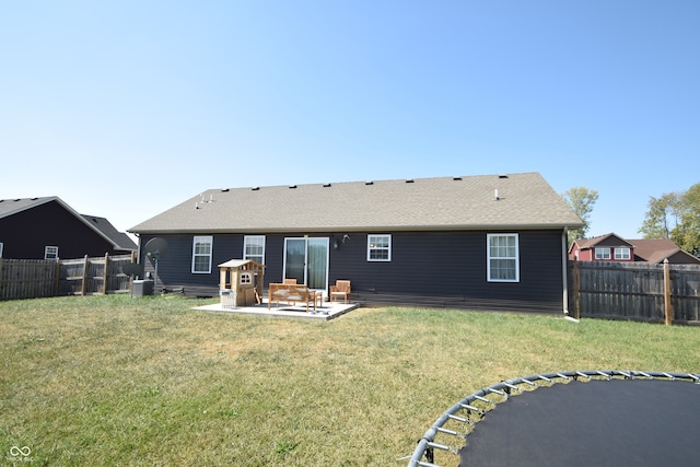 rear view of house with central AC unit, a lawn, and a patio