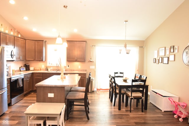 kitchen featuring pendant lighting, lofted ceiling, a kitchen island, electric range, and dark hardwood / wood-style flooring