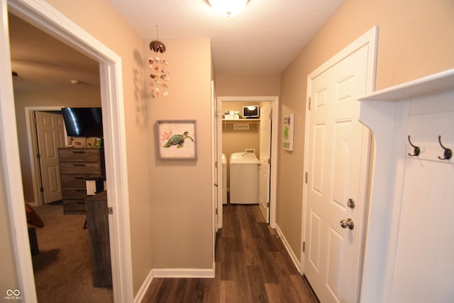 corridor with separate washer and dryer and dark hardwood / wood-style floors