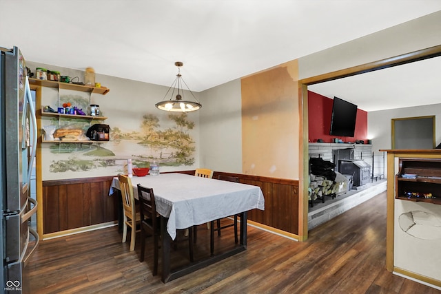 dining space featuring dark hardwood / wood-style floors and wood walls