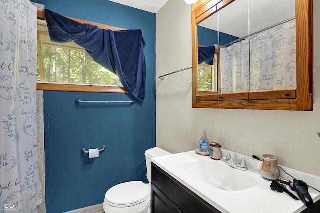 bathroom featuring a shower with curtain, vanity, and toilet