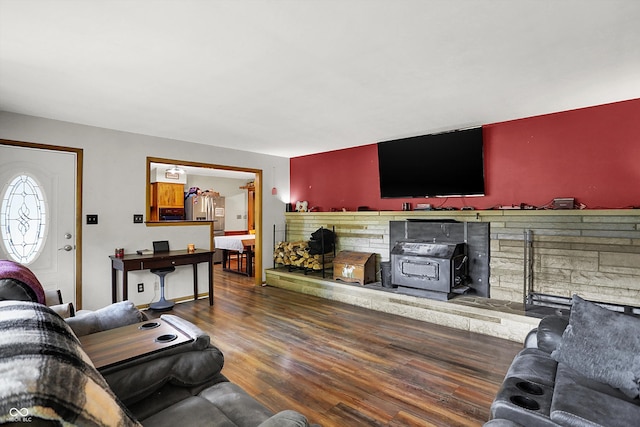 living room with a fireplace, dark hardwood / wood-style flooring, and a wood stove