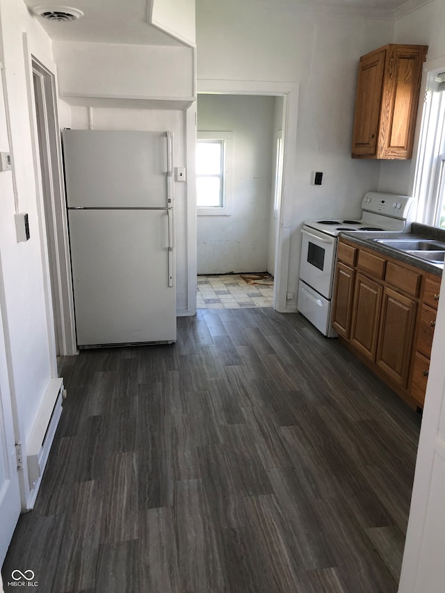 kitchen featuring white appliances, dark hardwood / wood-style flooring, and sink