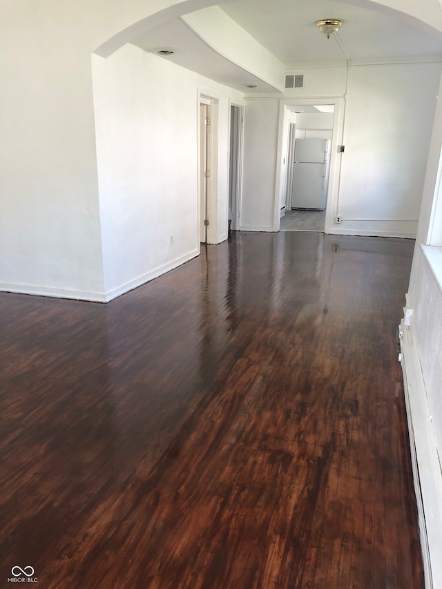 empty room with dark hardwood / wood-style flooring