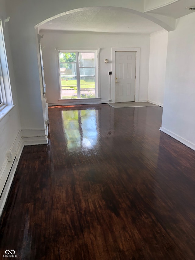 empty room with a baseboard radiator and dark hardwood / wood-style floors