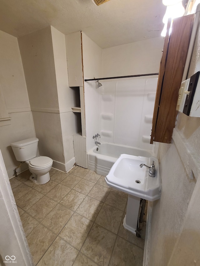 bathroom with shower / bathing tub combination, tile patterned floors, and toilet