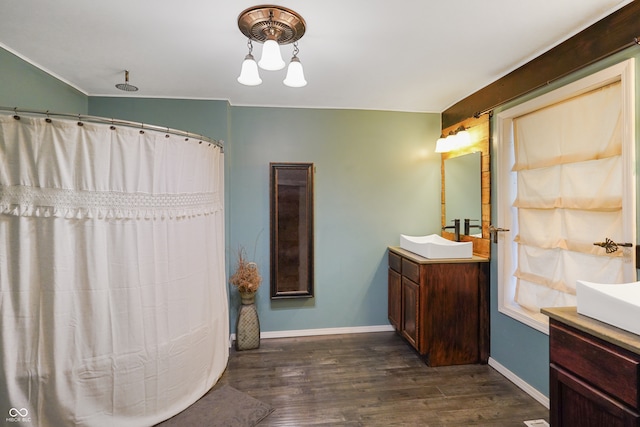 bathroom with vanity, wood-type flooring, and vaulted ceiling