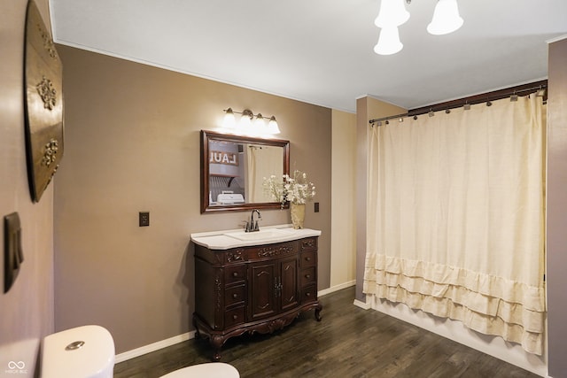 bathroom with vanity, wood-type flooring, a notable chandelier, and toilet