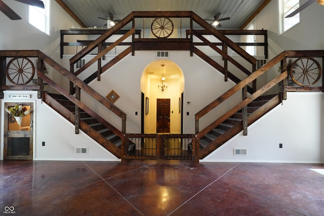 staircase with wood ceiling, concrete flooring, and high vaulted ceiling