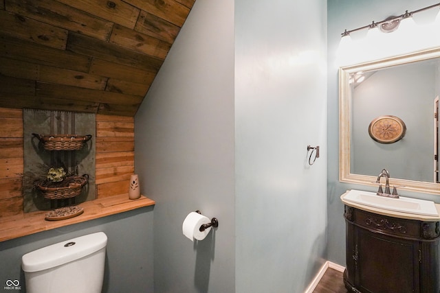 bathroom featuring wooden ceiling, lofted ceiling, toilet, vanity, and hardwood / wood-style flooring