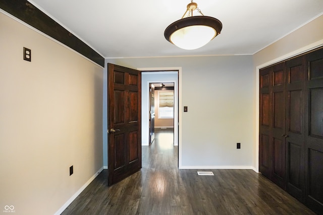 spare room featuring dark hardwood / wood-style floors and crown molding