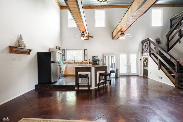 kitchen featuring a breakfast bar area, ceiling fan, wooden ceiling, and beam ceiling