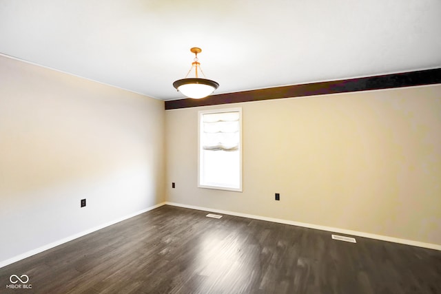 spare room featuring dark wood-type flooring