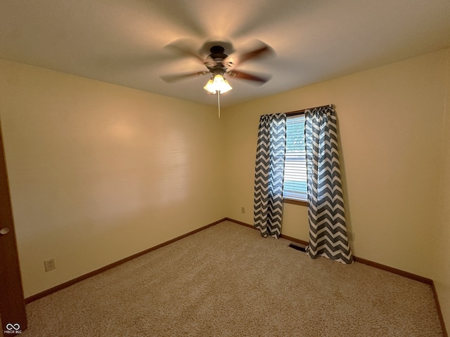 carpeted spare room featuring ceiling fan