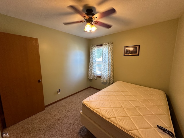 bedroom with a textured ceiling, carpet flooring, and ceiling fan