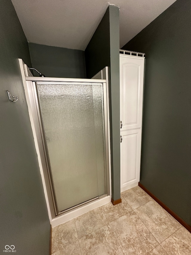 bathroom with an enclosed shower and tile patterned floors