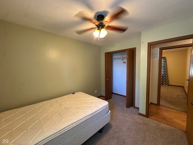 bedroom with a textured ceiling, carpet flooring, ceiling fan, and a closet