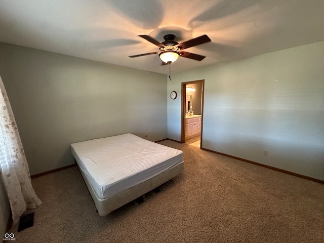 carpeted bedroom featuring ensuite bath and ceiling fan