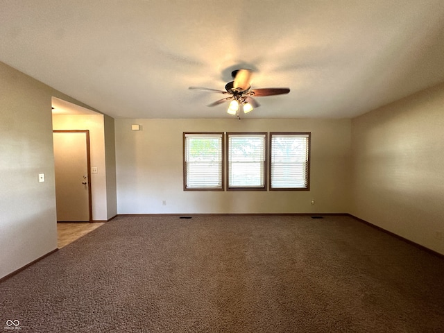 carpeted spare room featuring ceiling fan