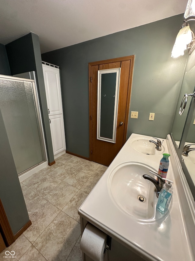 bathroom with tile patterned flooring, vanity, and a shower with door