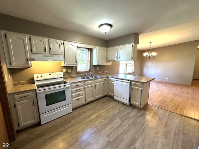 kitchen with pendant lighting, light hardwood / wood-style floors, a notable chandelier, kitchen peninsula, and white appliances