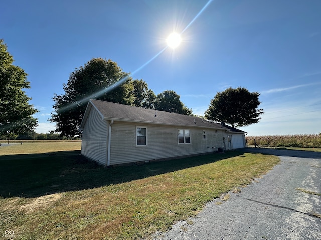 view of side of home featuring a lawn and a garage