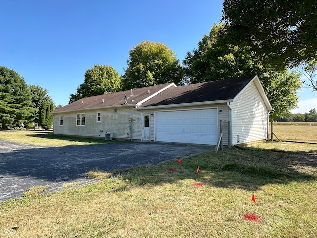 garage featuring a yard and central air condition unit