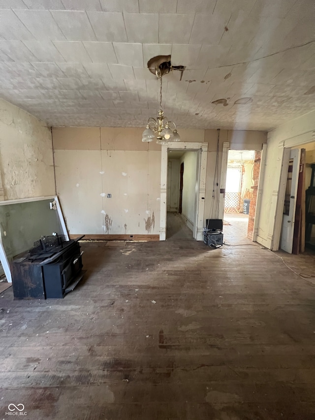 miscellaneous room featuring a chandelier and dark wood-type flooring