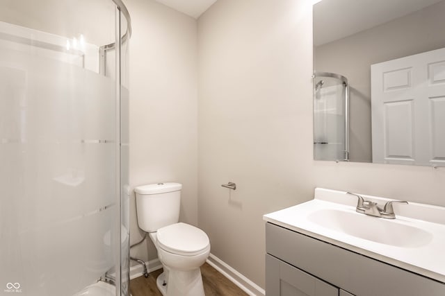 bathroom featuring vanity, a shower, toilet, and wood-type flooring