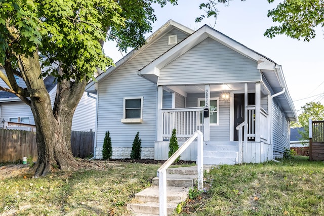 bungalow-style home with a front lawn and covered porch