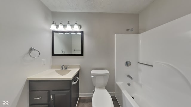 full bathroom featuring vanity, a textured ceiling, wood-type flooring, shower / bathing tub combination, and toilet