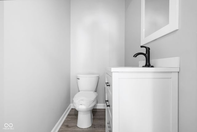 bathroom featuring hardwood / wood-style flooring, vanity, and toilet