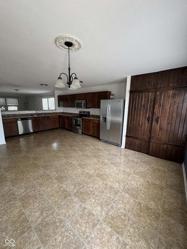 2307 Blackthorn Dr, Franklin, IN 46131 - kitchen with stainless steel appliances, a chandelier, hanging light fixtures, and dark brown cabinets