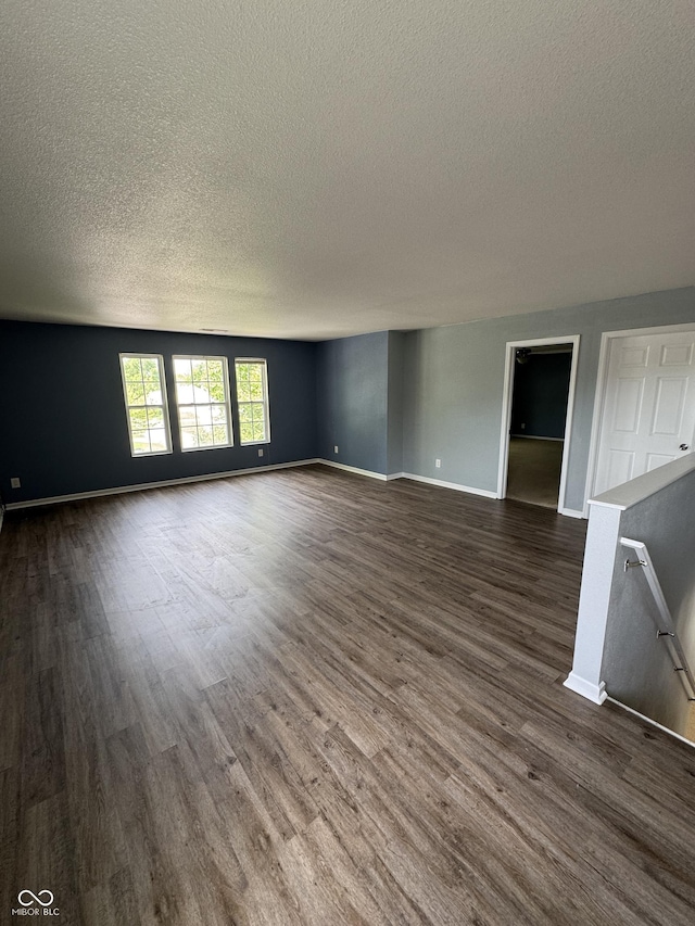 2307 Blackthorn Dr, Franklin, IN 46131 - unfurnished living room featuring a textured ceiling, dark wood-style floors, and baseboards