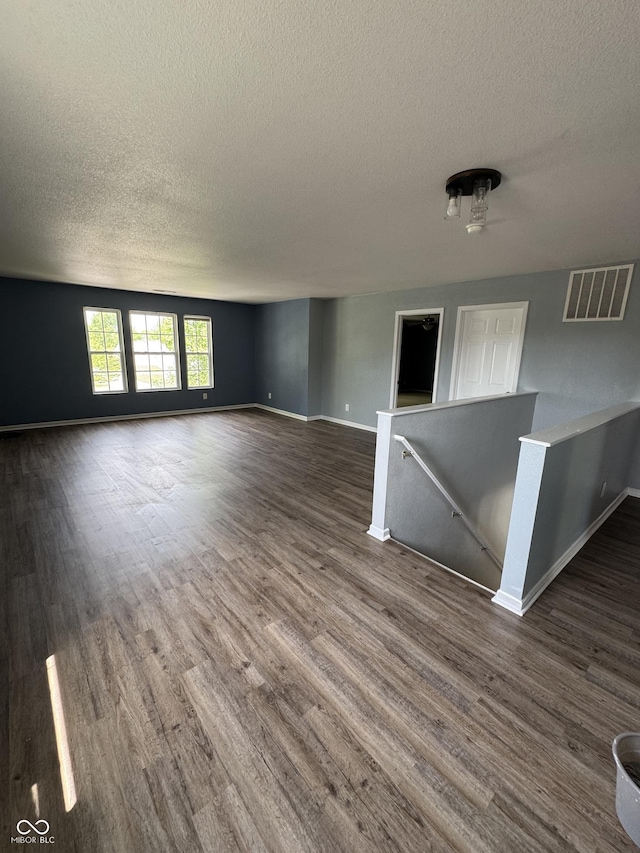 2307 Blackthorn Dr, Franklin, IN 46131 - unfurnished living room with a textured ceiling, dark wood-type flooring, and baseboards